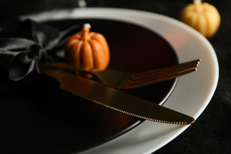 Festive table set for Halloween dinner with candles and cutleryの写真素材