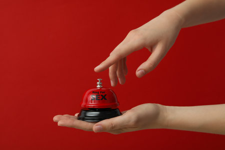 Bell for sex on a red background.