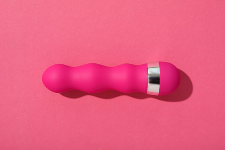 Pink silicone vibrator on a pink background.