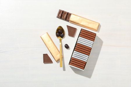 Chocolate bars with a golden spoon on a light backgroundの写真素材