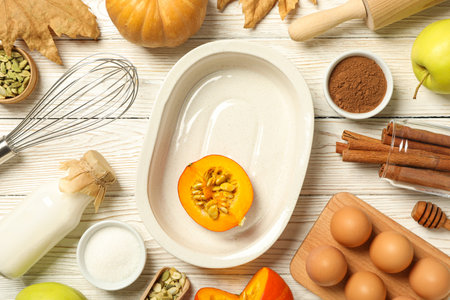 A white plate for the oven, with a pumpkin and eggs nearby.