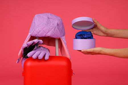A suitcase with winter gloves and a hatの写真素材