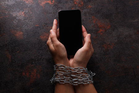 Human hands in a chain with a smartphoneの写真素材