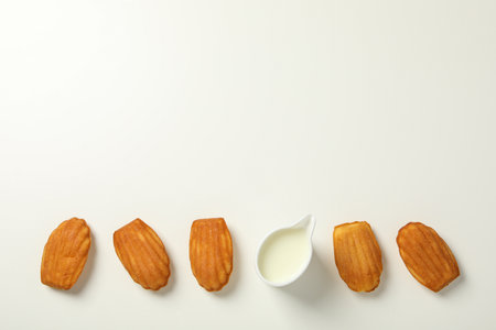 Madeleine cakes and cream on white background, space for text