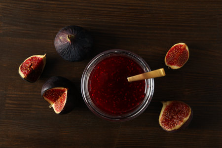 Figs and jars of jam on wooden background, top viewの写真素材