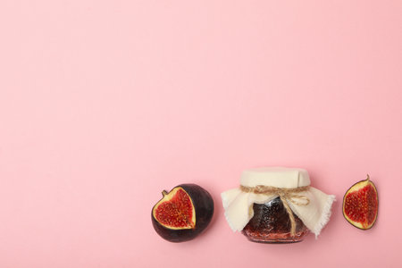 Figs and jar of jam on pink background, space for textの写真素材