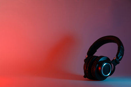Over-ear, black headphones, on a dark background.の写真素材
