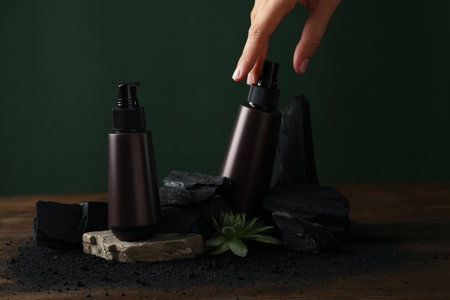 A bottle with natural, charcoal cosmetics on a green background.の写真素材
