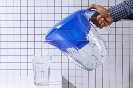 A water filter with a glass on a light background
