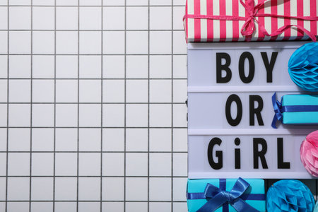Board with text, gift boxes and paper balls on light background, space for text