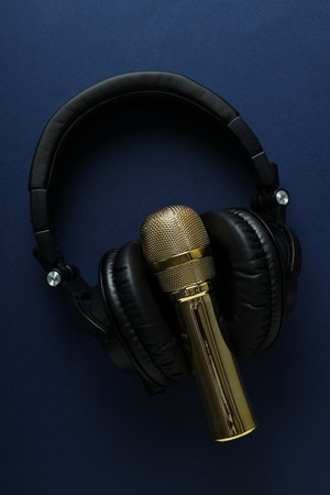 Black, large headphones, on the table with a microphone.の写真素材
