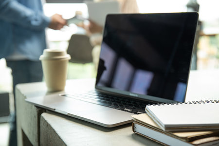 Close-up of a laptop near a cup of coffee on a tableの写真素材