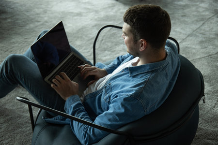 A cheerful young entrepreneur works in a modern workspaceの写真素材