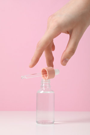 Hyaluronic acid in a bottle on a pink background.の写真素材