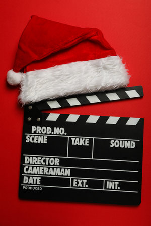 Clapperboard and Santa's hat on red background, top viewの写真素材