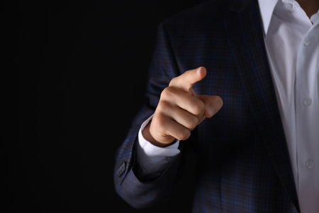 Man in suit and hand on dark background, space for textの写真素材