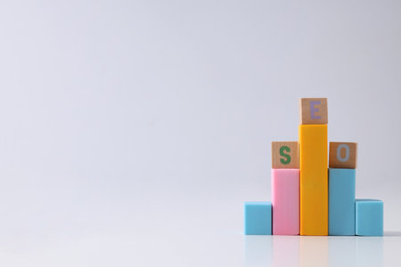 Colored blocks and wooden cubes with letters on light background, space for textの写真素材