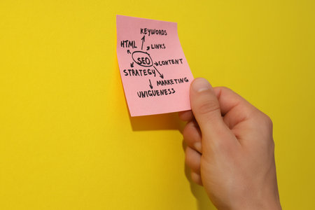 Note with diagram in hand on yellow background