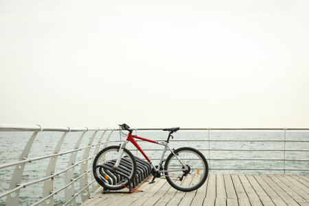 Red bicycle on wooden floor outdoors at seaの写真素材