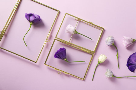 Set of fresh flowers and glass frames on purple background, top viewの写真素材