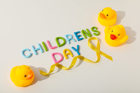 The inscription Children's Day with a yellow ribbon and a toy duckの写真素材