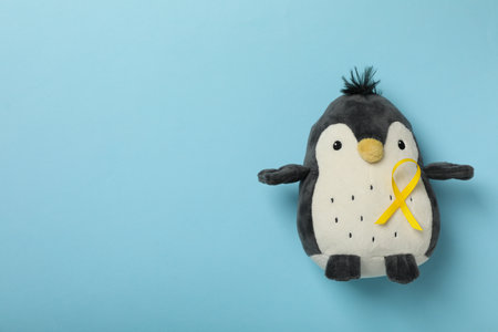 Toy soft penguin with a yellow ribbonの写真素材