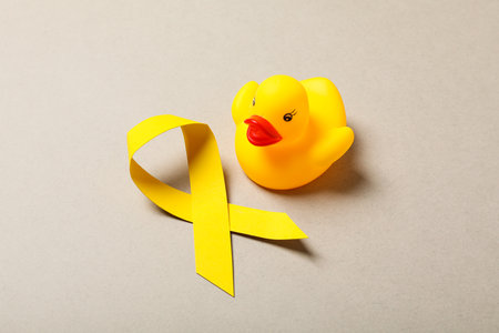 A yellow toy duck with a yellow ribbonの写真素材