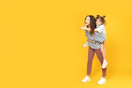 Mother and daughter are playing, on a yellow background.の写真素材