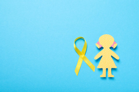 A paper figure of a girl with a yellow ribbonの写真素材