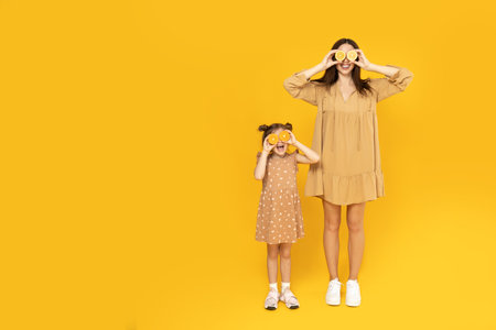 Mother and daughter are playing, on a yellow background.の写真素材