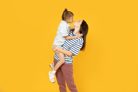 Mother and daughter are playing, on a yellow background.の写真素材