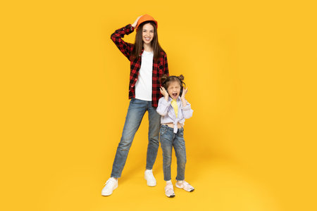 Mother and daughter in accessories for construction, on a yellow background.の写真素材