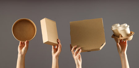 Cardboard boxes for food delivery, in the hands of women.