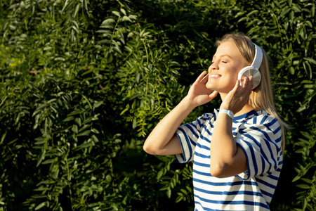 Girl in headphones on the street, close-up portrait.の写真素材