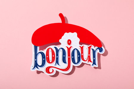 The word "bonjour" with a beret on a pink background.の写真素材