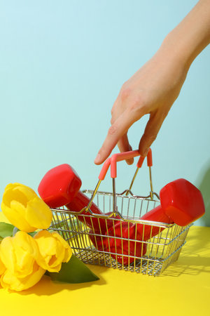 Red dumbbells in a shopping basket with flowers.の写真素材