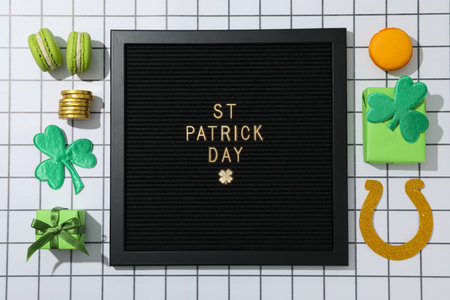 Black letter board with text, boxes, coins and clover leaves on light background, top viewの写真素材