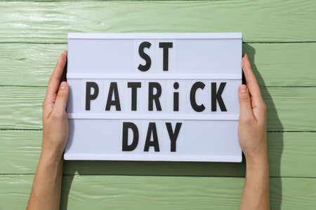 Light box with text in female hands on green wooden background, top viewの写真素材