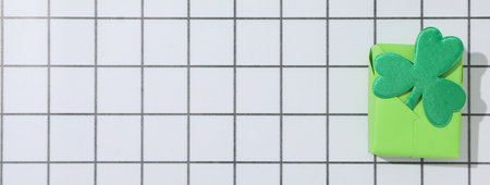 Gift box with clover leaf on light background, space for textの写真素材