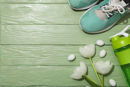 Green bottle for water, with flowers on a green background.の写真素材