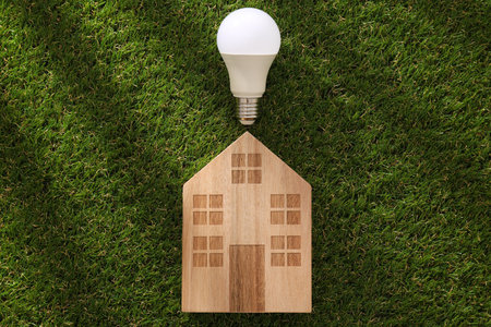 A wooden house with a lamp on the grass.の写真素材