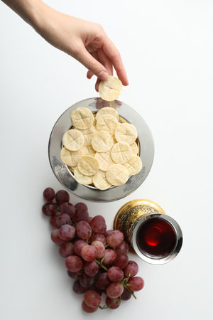 Bread, hand, grapes and cup with wine on white background, top viewの写真素材