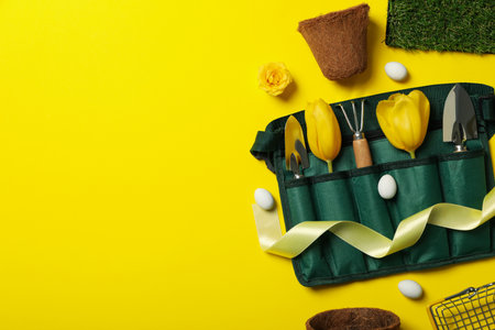 Garden tools and supplies, tulips and ribbon on yellow background, space for textの写真素材