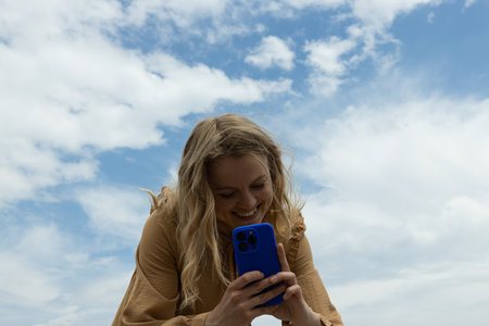 The girl takes a photo on the phone, bottom view.の写真素材