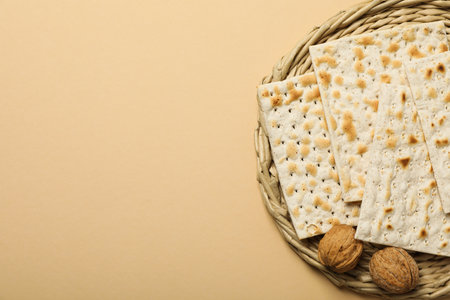 Matzo and nuts on beige background, space for text