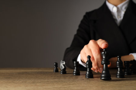 A man in a black suit with chess on the tableの写真素材