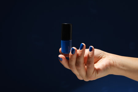 A blue jar of nail polish in a woman's hand