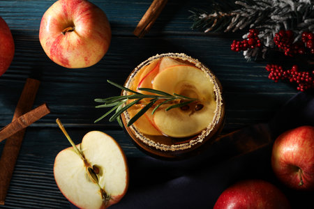 Glasses with apple cider, branches of christmas tree and apples on wooden background, top viewの写真素材