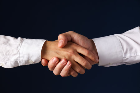 Male handshake close-up on a dark background