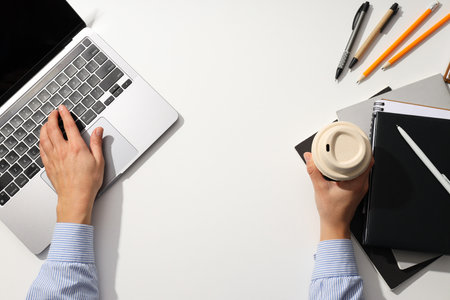 Male hands with laptop and coffee on the tableの写真素材